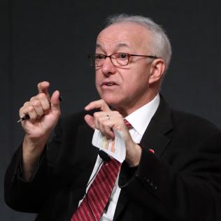 Dr. George Q. Daley seated, explains his work