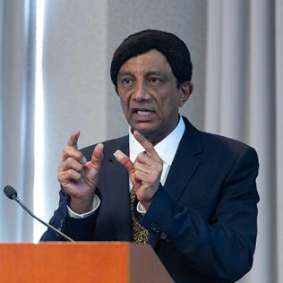 Dr. Manji gestures at the podium.