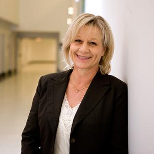 Bakaletz leans against a wall, smiling