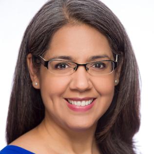 A smiling Patricia Valdez wearing a blue shirt.