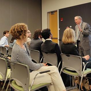 Tabak stands in front of classroom, addresses summer students