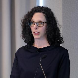 Alisa Roth speaks at podium in Neuroscience Center