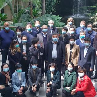 Group shot of people wearing masks covering nose and mouth.