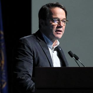 Dr. John Tisdale at podium