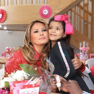 Child presents flowers to Mrs. Trump