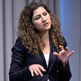 Shanechi extends her hands as she explains her work, in Neuroscience Center conference room.