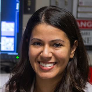 A smiling Dr. Eleni Frangos in the lab