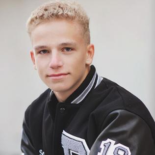 Luke poses in a black leather jacket.