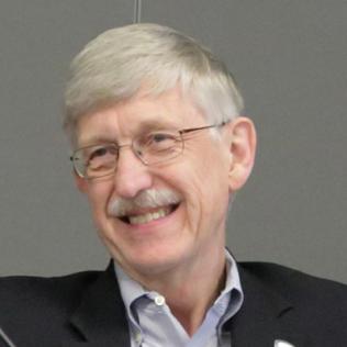 A smiling Collins seated by microphone