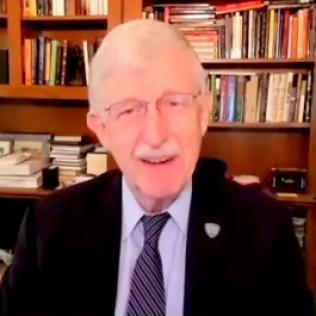 screenshot of Collins, smiling in suit and tie