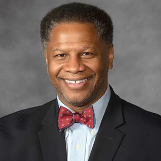 Head shot of a smiling Winn, wearing a tuxedo