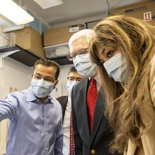 Sessions and a a group look at where Bharti points off screen