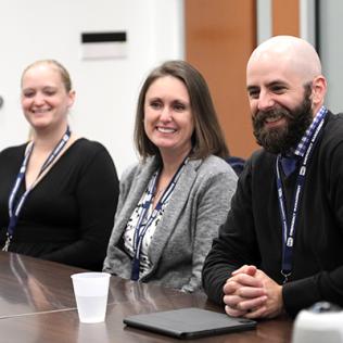 Three staff sit at a conference table