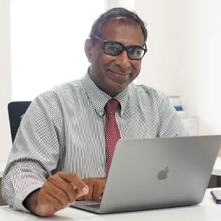 Mathew sits with his laptop