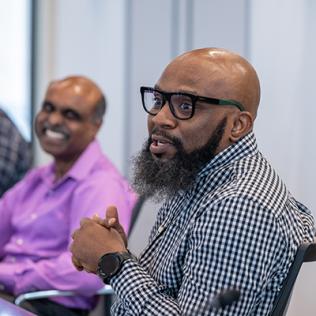 Owoade speaks while Devaraj laughs