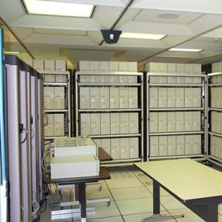 dozens beige boxes stacked on metal shelving units