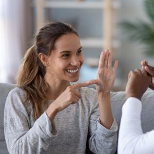 Two people speaking to each other using sign language