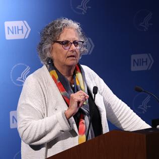 Sandler talks into microphone at podium in Lipsett Amphitheater