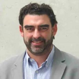 Dr. Nick Lane, wearing a gray suit jacket and blue and white striped shirt