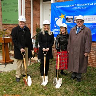 The event's speakers hold ceremonial gold shovels in front of the quarters