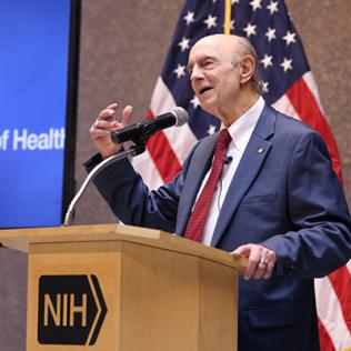 Alter speaks at a podium