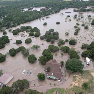 Aerial view of a neighborhood under water, with houses and cars submerged