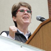Shellie Pfohl with fist clenched gives motivational speech at podium
