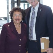 Collins and Lowey stand, smiling in Clinical Center atrium.