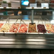 Several serving trays in a row, each containing a red-colored food item