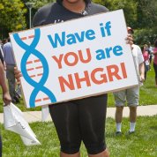 An NHGRI staffer holds up a sign.