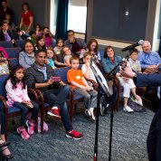 Dr. Collins sings to kids assembled in Wilson Hall.