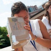 A woman looks through an eclipse viewer