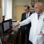 Rosenberg points at a computer screen as Azar looks on.
