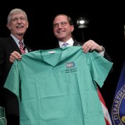 Collins presents the Secretary with a set of scrubs.