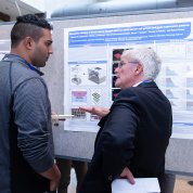 Dr. Michael Gottesman discusses a poster with a festival attendee.