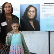 Dr. Emmeline Edwards of NCCIH and her granddaughters next to poster with her photo