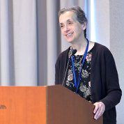 Schor speaks from podium.