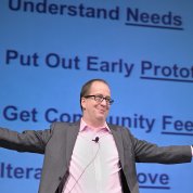 Eric Dishman smiles with outstretched arms as he explains the All of Us innovation process.