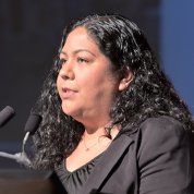 Cohort participant Ana Pavón speaks at podium