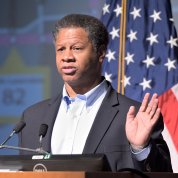 Dr. Robert Winn with raised hand speaks at podium