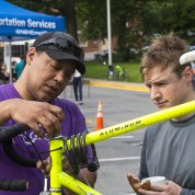 A technician works on an NIH'er's yellow bike outside bldg. 1.