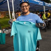 Cyclist holds up blue 2019 bike to work day tee shirt.
