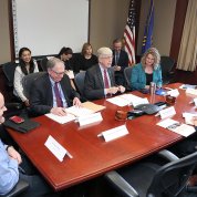 Group seated around mahogany conference table