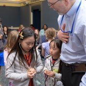 Kids wearing stethoscopes listen to each other's heartbeats.
