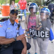 Cpl. Alvin Maker helps kids try on shield and helmets.