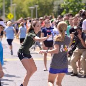 A runner hands off a baton to another runner