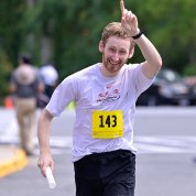 Short raises his arm as he crosses the finish line