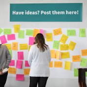 The wall features neon-colored post-it notes