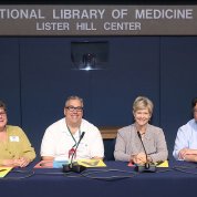 Four employees sit at a table facing the camera