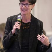 Langevin stands speaking into the microphone.